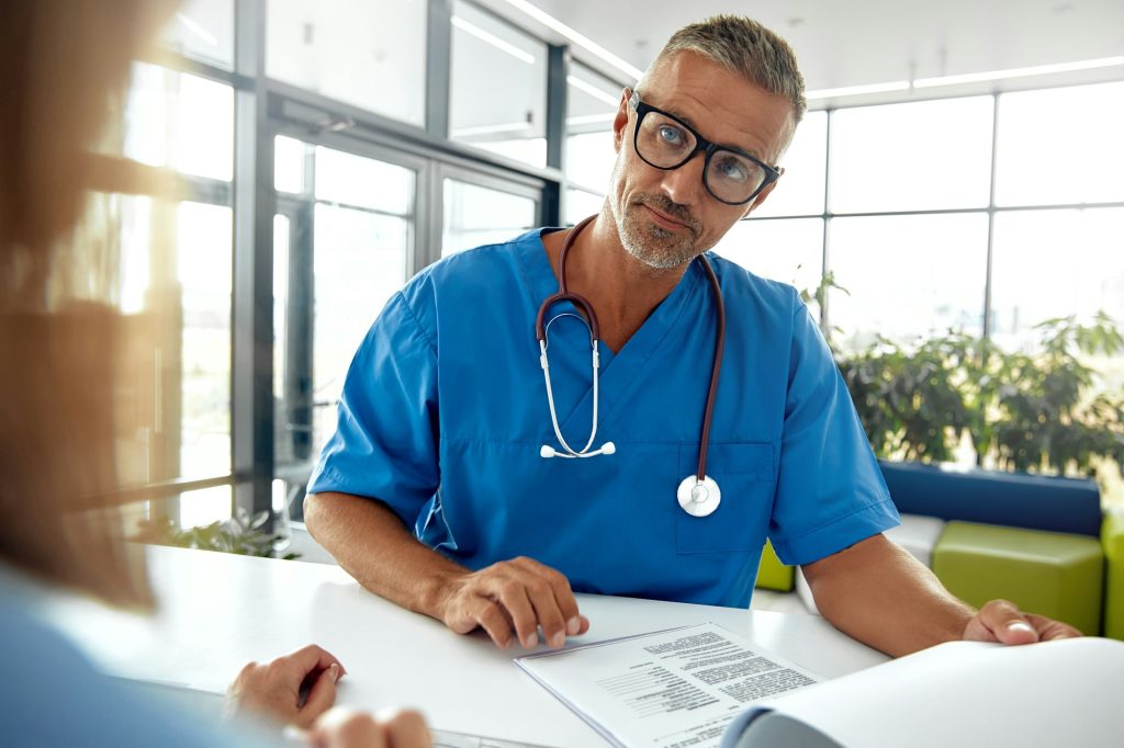 A Friendly Medical Receptionist is Actively Assisting a Patient in a Modern Healthcare Facility