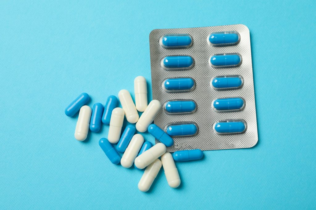 Blister pack and pills on blue background