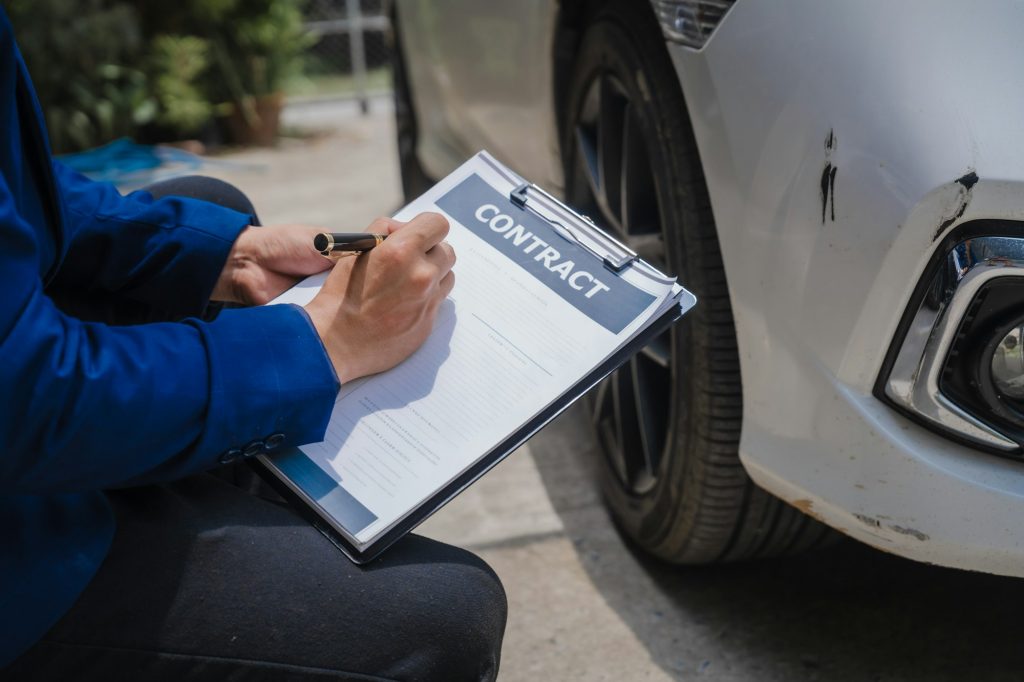 businessman in suit and car auto insurance agent assess car damage, discussing deductible, claims