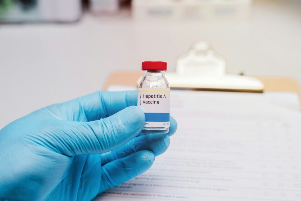 Doctor holding a vial of hepatitis A vaccine, vaccination concept