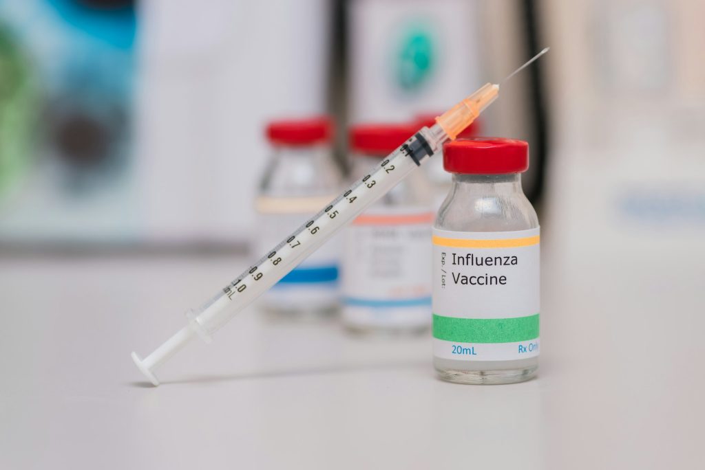 flu shot vaccination concept, syringe next to influenza vaccine vial