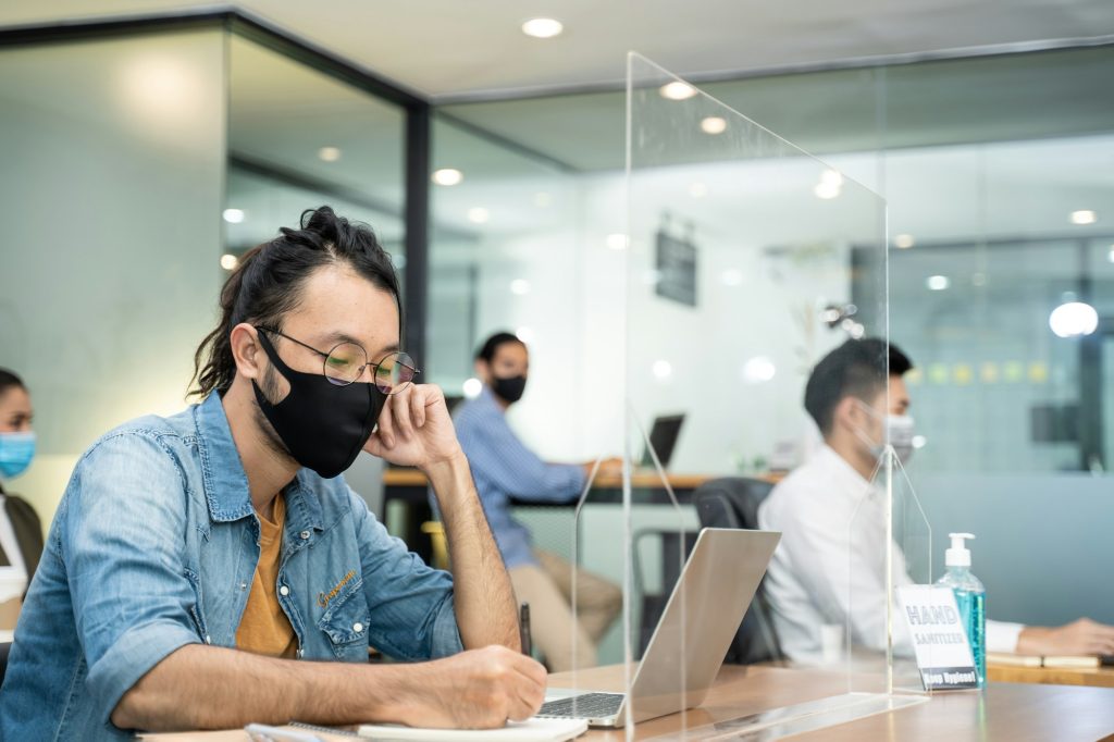 Group of Asian business people working in office with new normal social distancing.