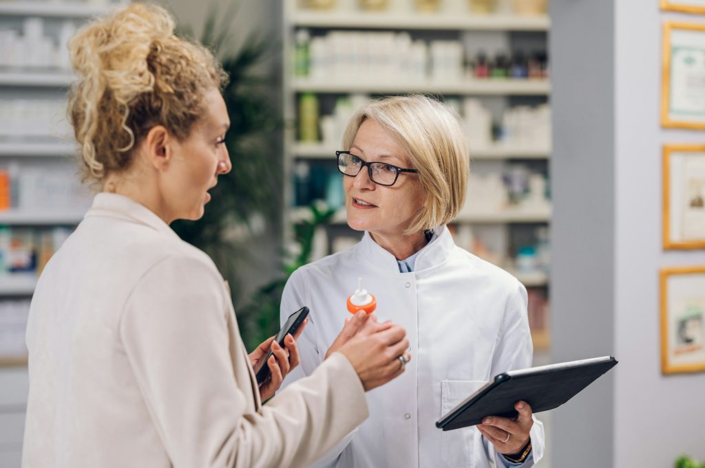 Portrait of a senior pharmacist talking with a customer in a pharmacy